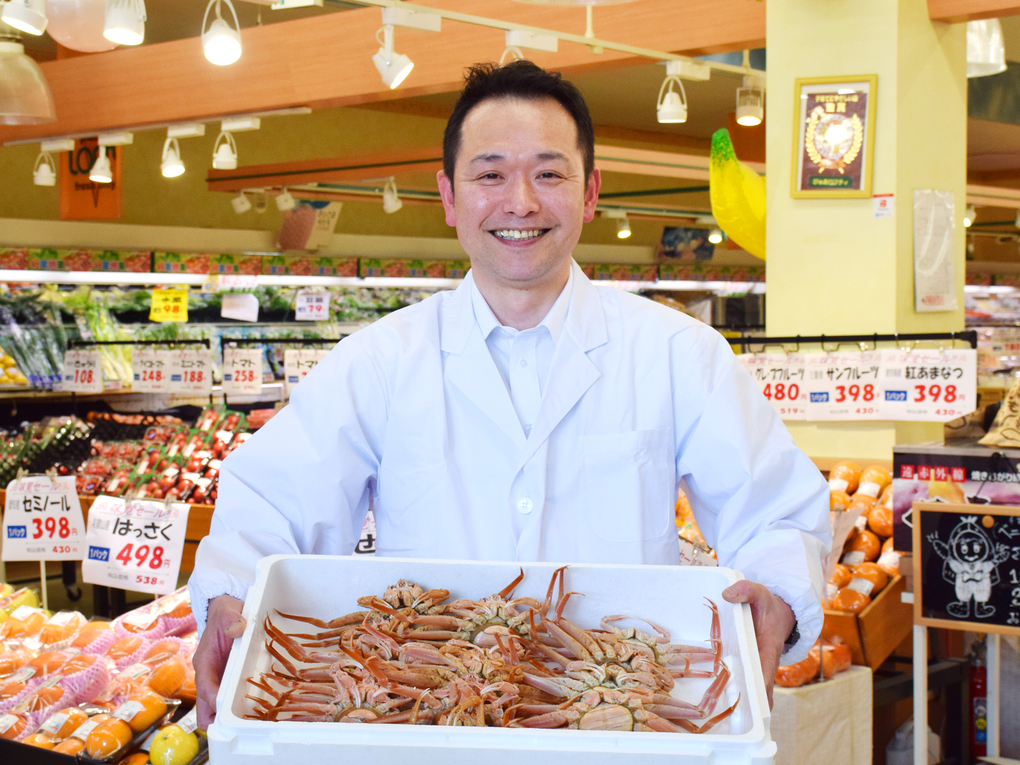 ぴゅあロフティの店内でカニを手に笑顔の上野真人氏